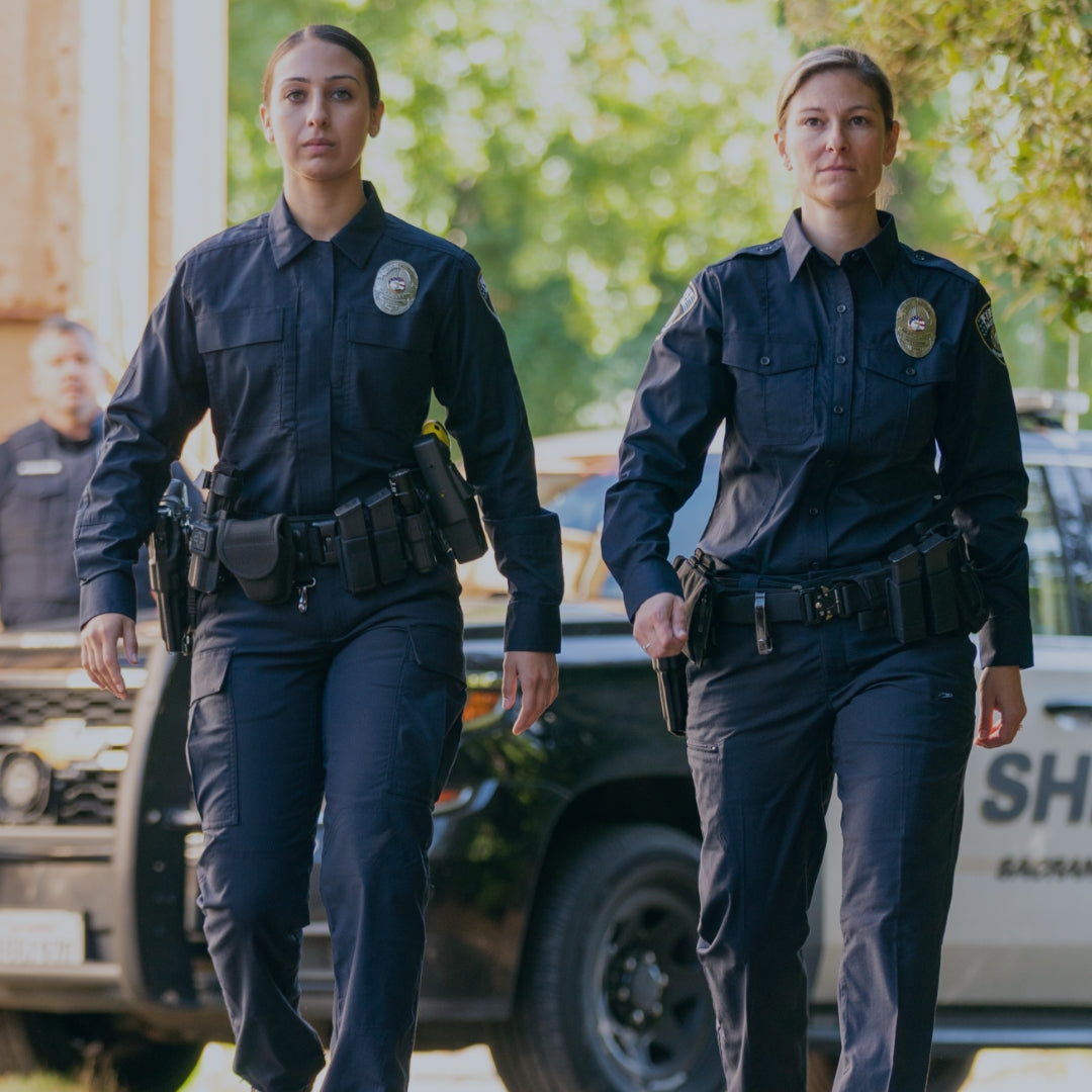 Two police officers in full midnight navy uniform. Shop Law Enforcement.